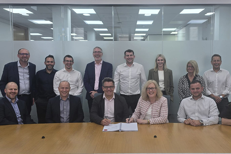 12 people standing behind a conference table