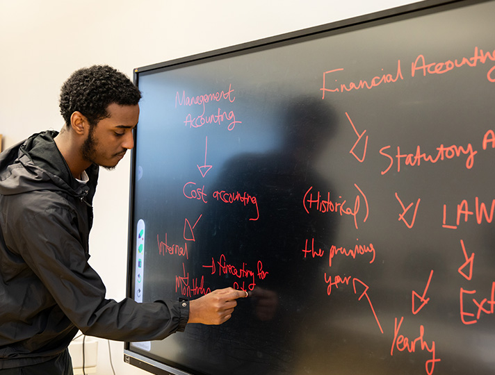 Student working at a board in classroom